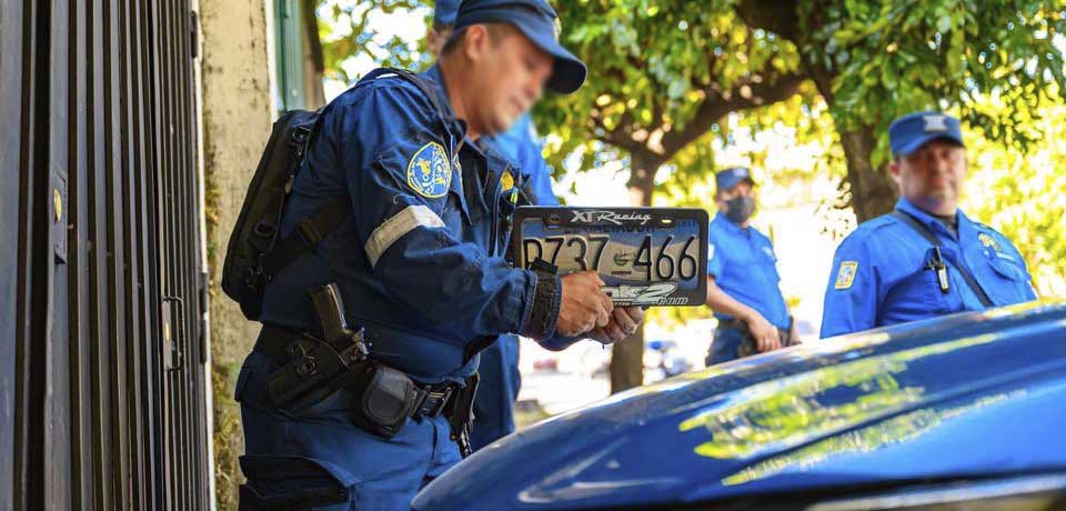 Quitan las placas a vehículos estacionados sobre la acera en San Salvador