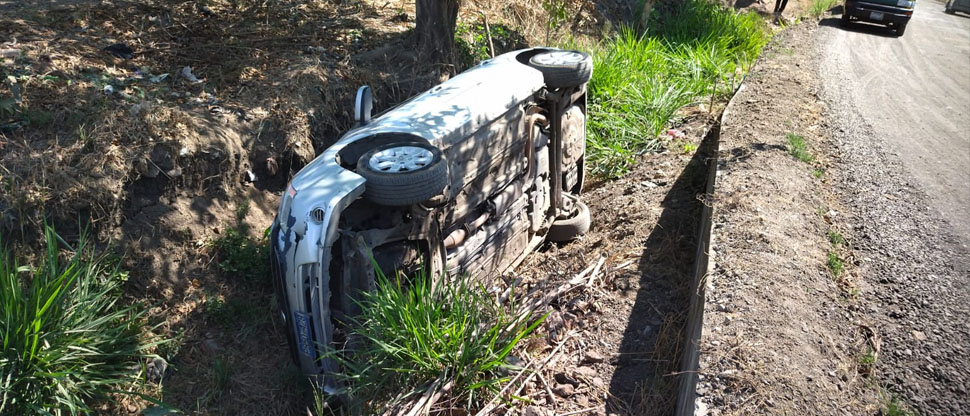 Conductora sufre lesiones tras perder el control del su carro, salirse de la calle y volcar