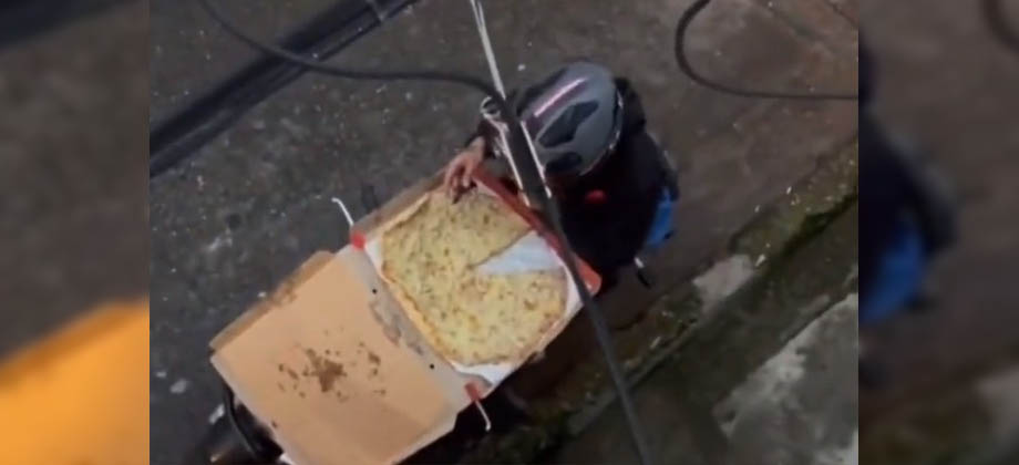 Graban a repartidor de comida comiéndose la pizza de un cliente