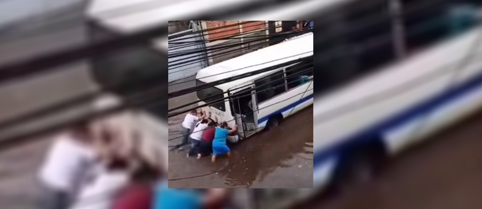 Viralizan video de mujeres empujando microbús que quedó atascado por las lluvias en Apopa