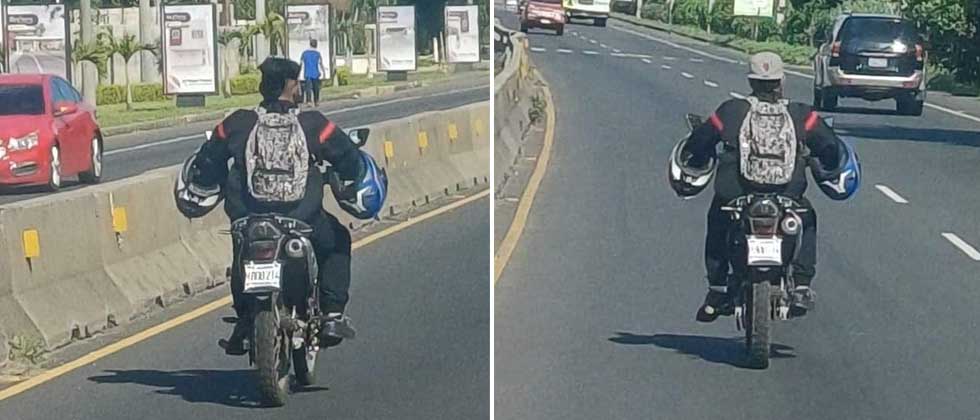 Captan a motociclista con dos cascos en los antebrazos y su cabeza expuesta