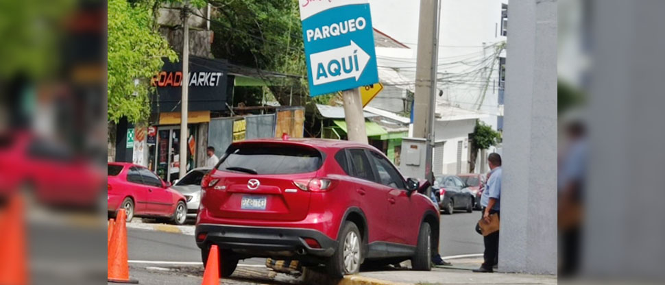 Conductor choca contra poste con letrero que indica dónde está el parqueo