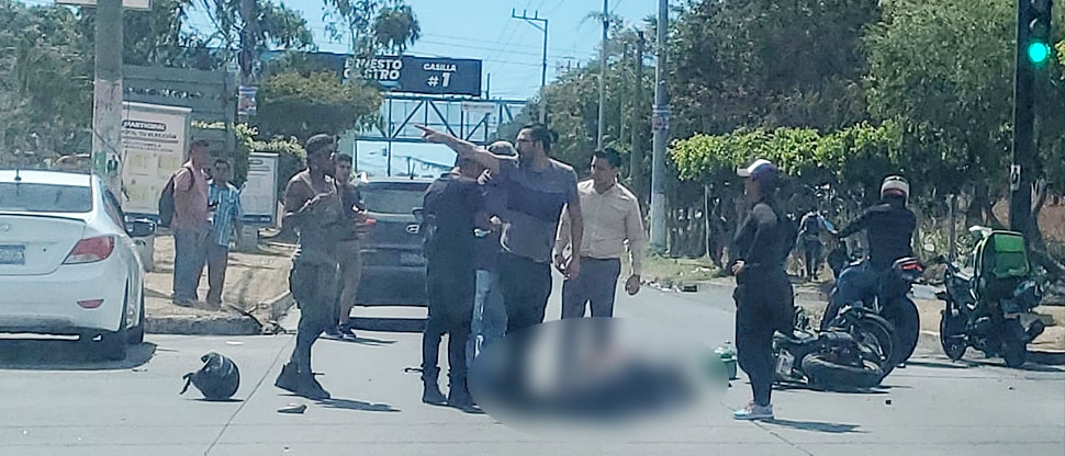 Motocilcista queda tendido sobre el pavimento tras colisionar contra vehículo