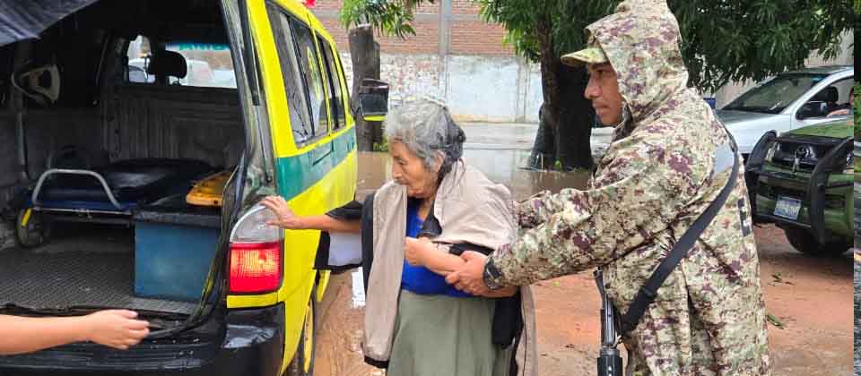 Soldados ayudan a una ancianita para trasladarla a un albergue por las fuertes lluvias