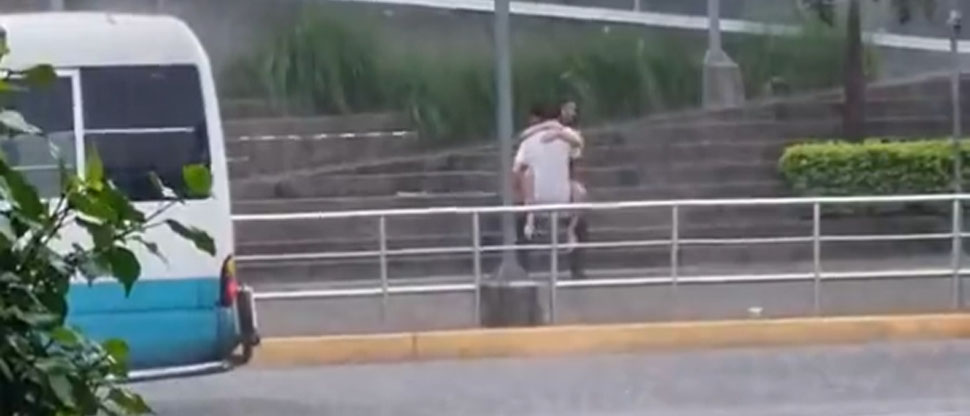 Jovencita se lanza a los brazos de su amado en plena tormenta afuera de centro comercial de Apopa 