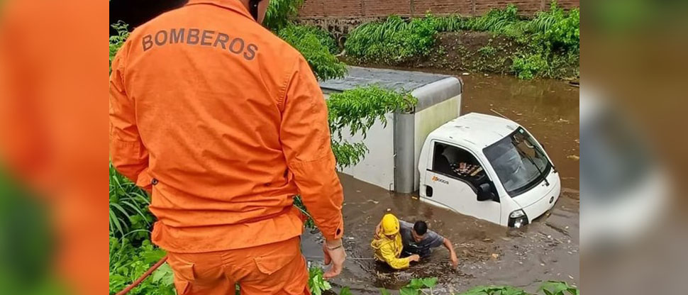 Bomberos rescatan a dos personas que quedaron atrapadas en camión por inundación en Sonsonate