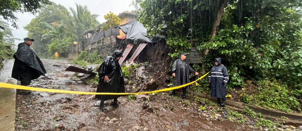 Policías remueven escombros de un muro colapsado en una vivienda en Sonsonate