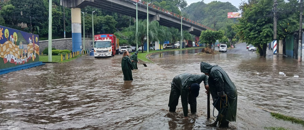 Trabajadores de la alcaldía de San Salvador drenan calles anegadas por tragantes tapados con basura