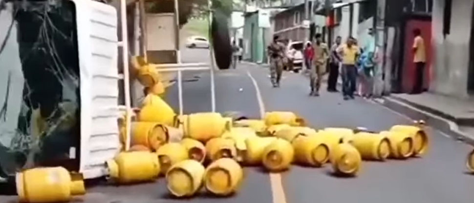 Camión que transportaba tambos de gas vuelca arrojando su carga en la calle