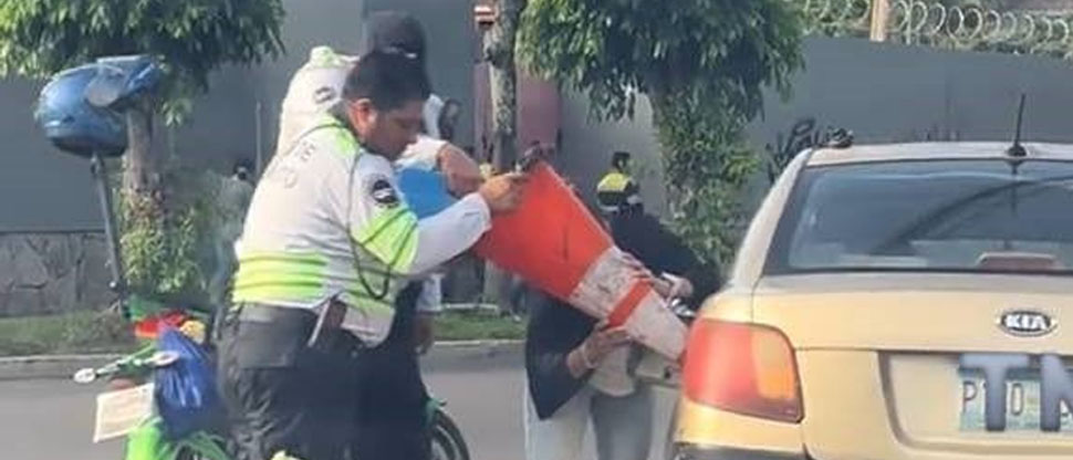 Gestor de tráfico utiliza cono como embudo para ayudar a conductora que se quedó sin gasolina