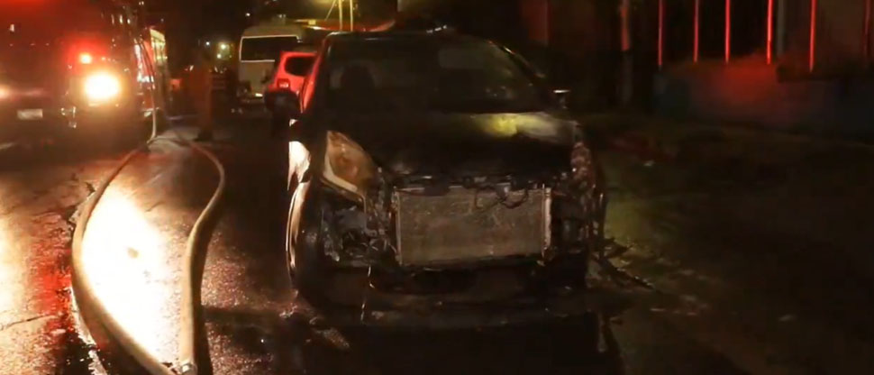 Incendio consume autobús y carro en un parqueo en la Santísima Trinidad
