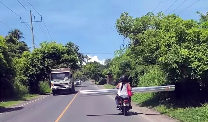 Conductor arriesga su vida y la de su acompañante al transportar material de construcción en su moto
