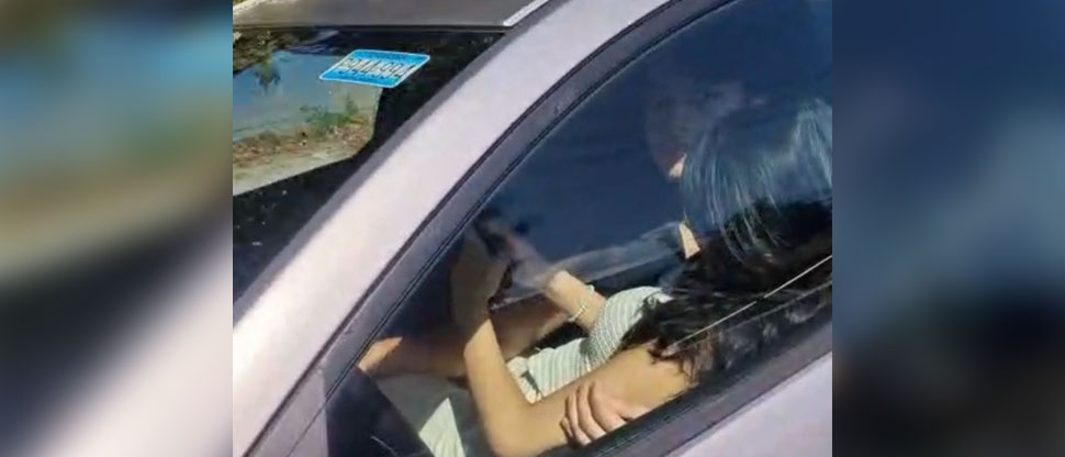 Sancionan a conductor captado manejando con su novia en las piernas