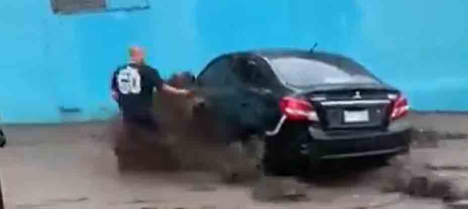 Hombre se mete a fuerte correntada para salvar su carro