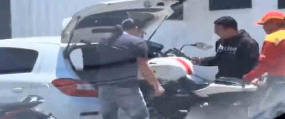 Captan a biker y su acompañante subiendo su moto al baúl de un automóvil